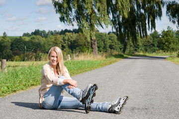 Inline skates young woman sitting asphalt road