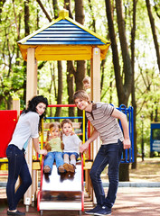 Fototapeta na wymiar Family with children on playground outdoor.