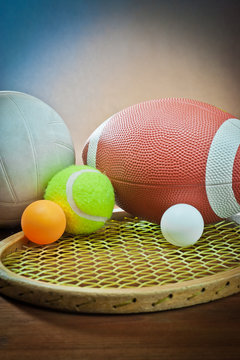 Assorted sports equipment.Tennis and racket,rugby and volleyball