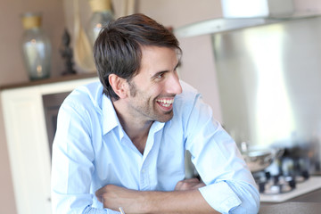 Fototapeta premium Smiling man standing in domestic kitchen