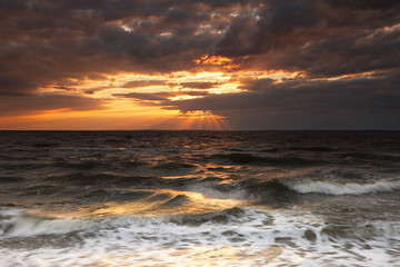 Naklejka na ściany i meble sunset at the stormy sea