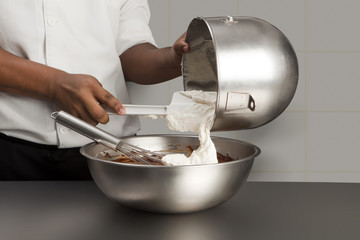 Cuisinier incorporant des blancs en neige au chocolat fondu