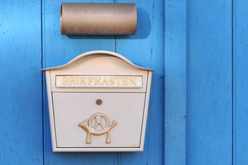 Briefkasten an blauer Tür