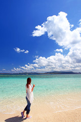 Fototapeta na wymiar 水納島の美しい砂浜を散歩する女性