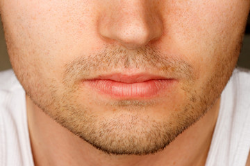 Close up of man's face sporting a 5 o'clock shadow