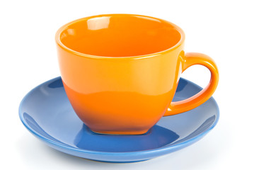 Orange tea cup on blue saucer isolated on white
