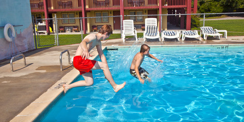 Naklejka premium brothers have fun jumping in the pool