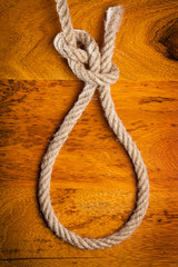 Obraz premium Rope knot on a teak wood background