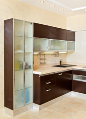 Part of modern Kitchen interior with cupboard in warm tones