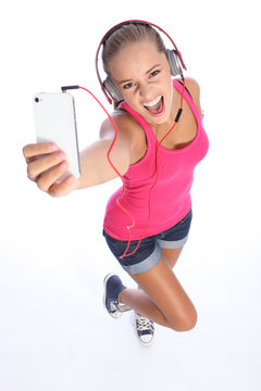 Happy sexy teenage girl has music fun with phone