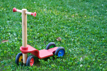 A single push-scooter for children in a garden.
