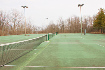 Series of side-by-side tennis courts in a rural resort setting