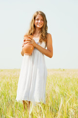 Fototapeta na wymiar girl with jug at cereals field