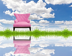 pink sofa on green grass and blue sky