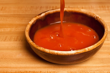 Tomato soup being poured into a ceramic bowl