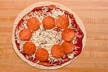 Uncooked pepperoni and cheese tortilla pizza