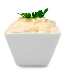 Delicious mayonnaise in bowl and parsley isolated on white