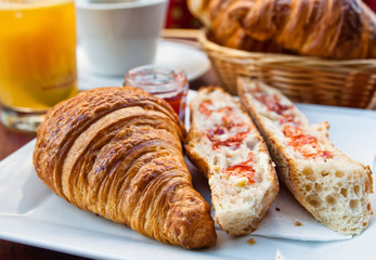 Breakfast with coffee and croissants in a basket on table