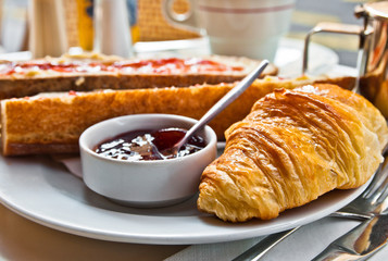 Breakfast with coffee and croissants in a basket on table