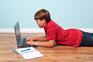 Boy typing on his laptop