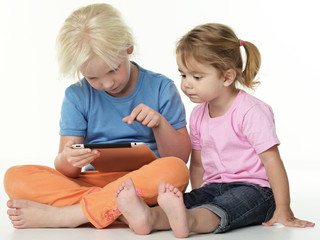 Cute girlfriends sitting on the floor and playing with touchpad