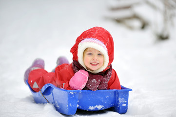 Fototapeta na wymiar Little girl on sleigh