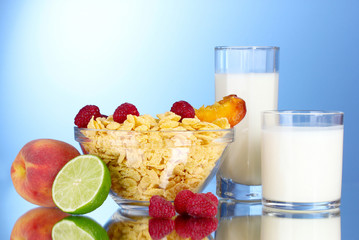 tasty cornflakes, fruit in glass bowl and milk