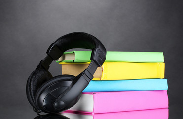 Headphones on books on gray background