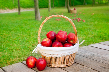 basket of red apples on wood floor