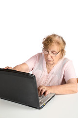 The old woman in glasses looks at the screen notebook isolated