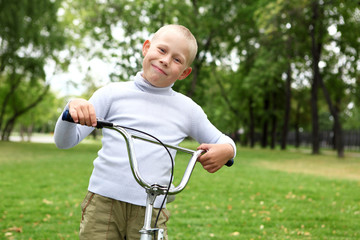 Boy on a bicycle in the green park