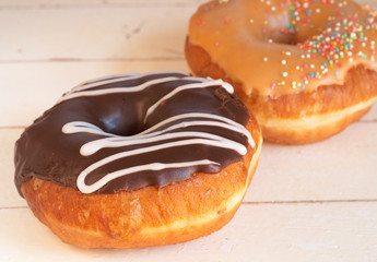 Two donuts covered in caramel and chocolate icing