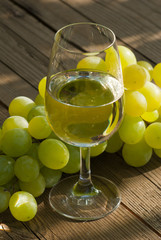 wine and grapes on wooden table