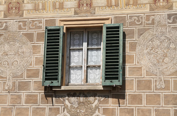 window with shutters on wall decorated sgraffiti