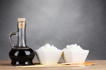 Bowls of cooked rice and soy sauce in jar