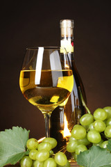 Glass of wine,bottle and grapes on yellow background