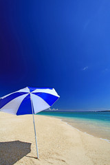 水納島の青く澄んだ海とビーチパラソル