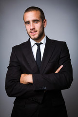 Portrait of a handsome young business man on grey background