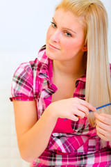 Portrait of pretty woman combing hair