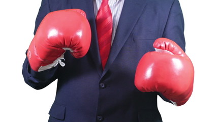 Businessman in suit fighting in red boxing gloves. - Powered by Adobe