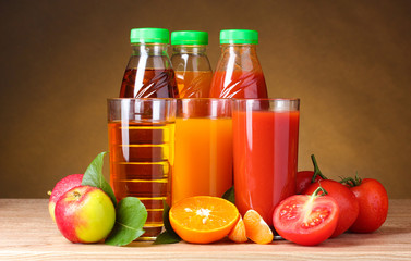 Different juices and fruits on wooden table