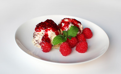 Ice cream with raspberries and mint on white