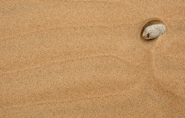 Fototapeta na wymiar Sand background with stone