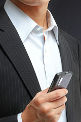 business man in black suit working on pda or smartphone