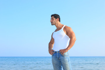 Handsome man in jeans by the sea