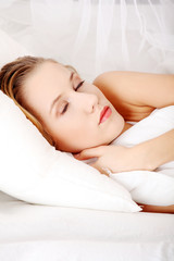 Fototapeta na wymiar Young woman sleeping on the bed