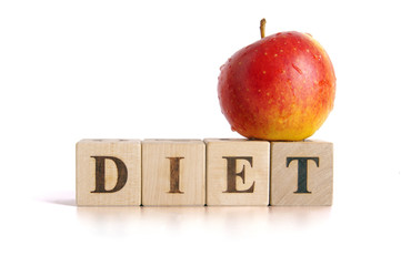 Red apple and cubes with letters in front of a white background