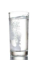 Glass with efervescent tablet in water isolated on white
