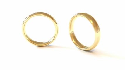Dropped wedding rings isolated on the white. Slow motion