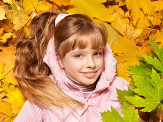 Kid in autumn orange leaves.